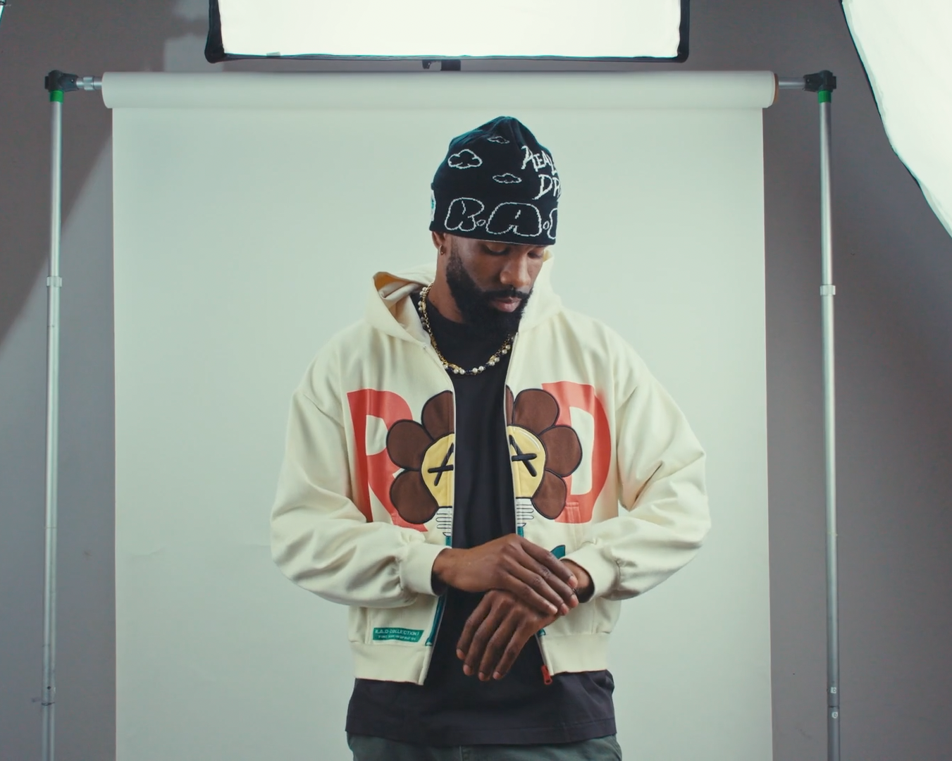 Person wearing a colorful jacket with a brand logo in a studio setting